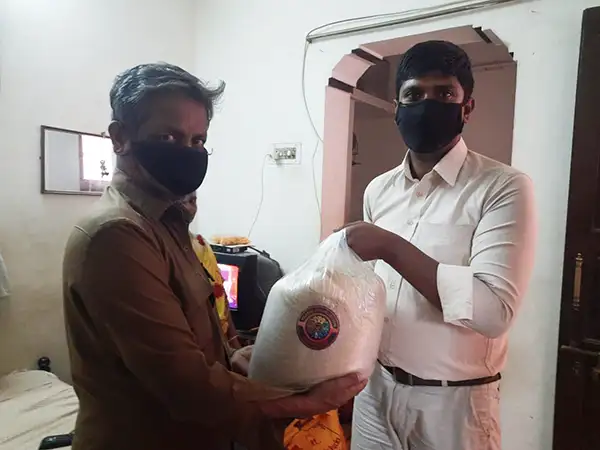 Volunteer handing over a sack of rice